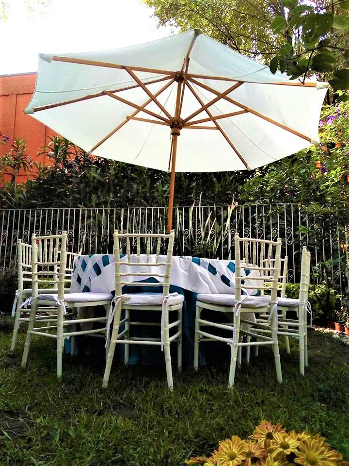 mesa redonda con mantel azul turquesa y silla Tiffany blanca