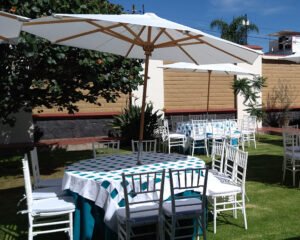 mesa redonda con mantel azul y sombrilla