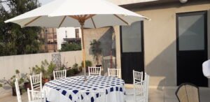 silla Tiffany blanca con mesa redonda y sombrilla 1